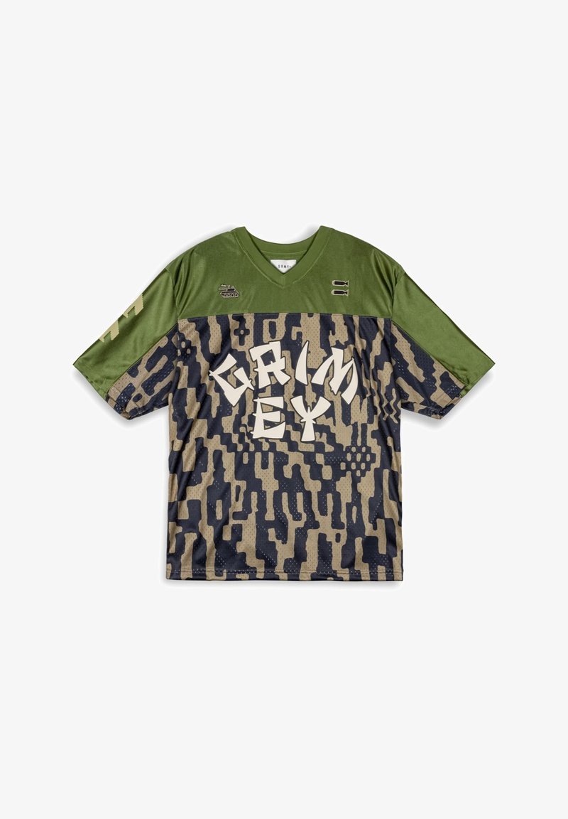 Jersey de manga corta en un patrón de camuflaje verde y beige. Cuenta con un gran texto blanco "GRIMEY" y sutiles acentos texturizados. Diseño con cuello en V.