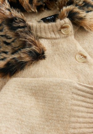 Pulover bej tricotat, cu un guler din blană cu print de leopard, având două butoane rotunde și un model texturat, cu nervuri pe margine.