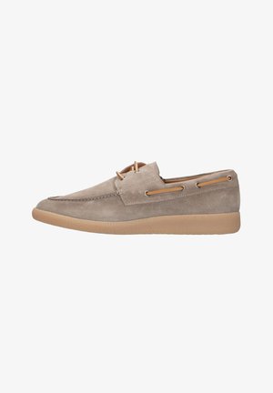 Beige suède instapper loafer met moc-toe stiksels, leren veterdetail rondom de kraag en een lichtbruine rubberen zool.