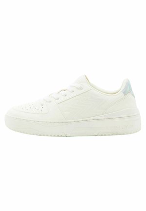 Zapatilla blanca con una parte superior sintética suave, diseño con cordones, puntera perforada y una suela ligeramente texturizada. Incluye un sutil acento iridiscente.