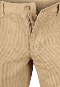 Beige corduroy broek met verticale ribbels, gedeeltelijk opengeritste rits en een viergaatjesknop bij de taille.