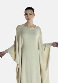 Robe kaftan beige avec un col rond et de longues manches fluides. Fabriquée en tissu léger avec une texture douce et un design minimaliste.