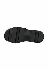 Semelle de chaussure en caoutchouc noir avec surface texturée, présentant une forme courbée et des rainures horizontales pour l'adhérence. Logo de la marque embossé au centre.