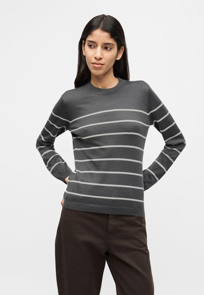 Γκρι ριγέ πουλόβερ με ανοιχτό γκρι οριζόντιες ρίγες, στρογγυλή λαιμόκοψη και μακριά μανίκια, σε συνδυασμό με σκούρο καφέ παντελόνι. Μαλακή υφή πλεκτού.