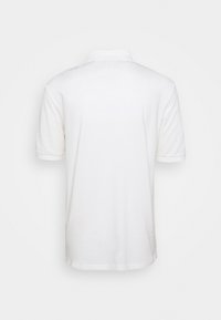 Polo shirt blanc à manches courtes présenté de dos avec un col et un ourlet simple sur fond blanc.