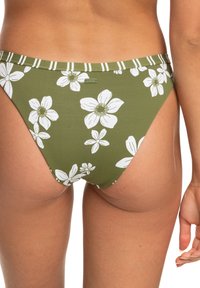Olive green bikini bottom with white floral pattern, striped waistband, high-cut design, and Roxy branding on the back.