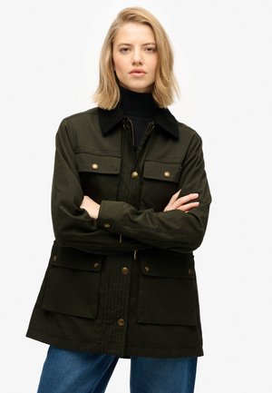 Veste vert foncé avec un col en velours côtelé, fermeture éclair et bouton, quatre poches avant et un design décontracté.
