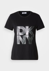 T-shirt preta de manga curta com grandes letras "DKNY" prateadas e brilhantes na frente e decote redondo.