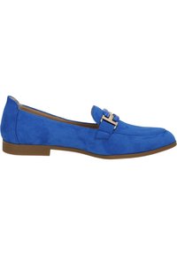 Mocasines de ante azul con suela plana, que presentan un acento de hebilla plateada. El diseño es elegante con una textura suave y detalles de costura sutiles.
