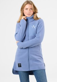 Giacca in pile blu chiaro con colletto alto, frontale con zip, tasche laterali e tasca sul petto con logo e etichetta sull'orlo inferiore.