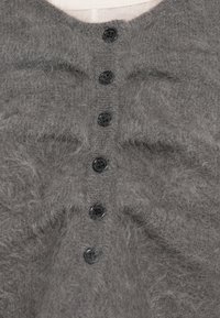 Cardigã cinza fofinha com sete botões pretos na frente. O tecido parece macio, com um acabamento texturizado e um leve brilho.