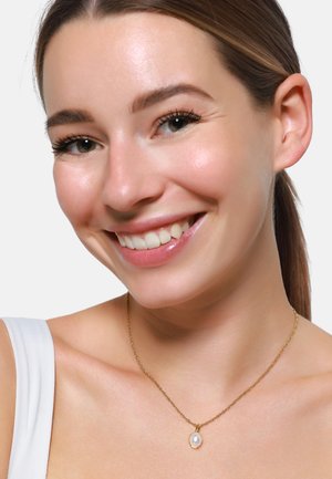 Collana in oro con pendente a forma di perla tonda, caratterizzata da una delicata texture attorcigliata e una lucentezza sottile. Il design è minimalista ed elegante.