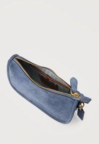Μπλε σουέντ πορτοφόλι χειρός με χρυσαφί φερμουάρ που είναι μερικώς ανοιχτό, αποκαλύπτοντας την εσωτερική επένδυση από ύφασμα και μια μικρή καφέ τσέπη μέσα.