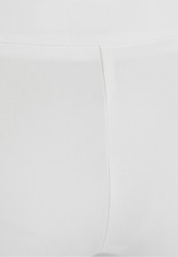 Bílá látka s hladkou strukturou, s přiléhavým střihem a viditelnými švy. Jednoduchý a minimalistický vzhled.