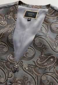Srebrna i szaro-biała kamizelka w wzór paisley z satynowym wykończeniem; posiada czarną metkę z napisem "NEXT Occasion" oraz detale z guzikami.