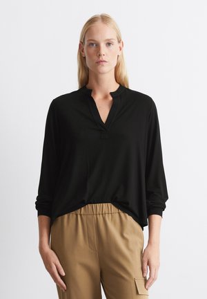 Black long-sleeve top with a V-neck and a small placket. Soft, lightweight fabric with a relaxed fit, paired with beige pants.