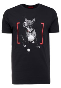 Camiseta de algodón negra con un gráfico de un perro sentado en blanco y gris con acentos rojos enmarcando la imagen. Diseño de manga corta y cuello redondo.