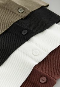 Neljä ribattu neuloskangaspaitaa pinottuna vaakasuoraan: oliivinvihreä, musta, valkoinen ja ruosteenvärinen, jokaisessa on vastaavat napit.