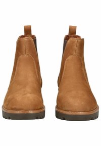 Botas Chelsea en ante marrón con paneles laterales elásticos, tiradores y una suela de goma marrón texturizada. Acabado suave con detalles de costura visibles.