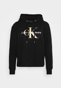 Svart hoodie i bomullsblandning med en framsidan logotyp som visar "Calvin Klein Jeans" i vitt och guld. Inkluderar justerbara snoddar och ribbade muddar.