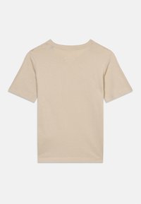 Φωτεινό μπεζ κοντομάνικο T-shirt από μαλακό ύφασμα, με στρογγυλή λαιμόκοψη και καθαρές ραφές στο τελείωμα και στα μανίκια.