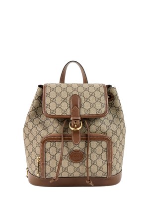 Beige en bruine Gucci rugzak met kenmerkend GG-patroon, leren afwerking, voorflap met gesp, trekkoordsluiting en een ritsvak.