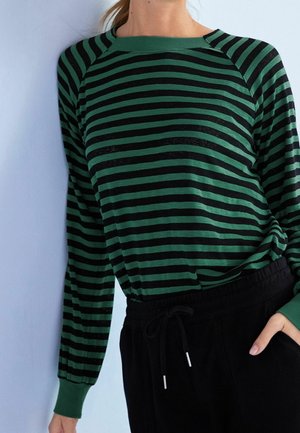 Green and black striped long-sleeve top with a crew neckline and ribbed cuffs, paired with black drawstring pants. Soft fabric texture.