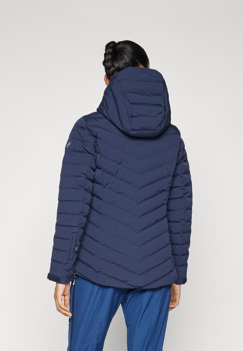 Marineblaue Steppjacke mit Kapuze, mit Chevron-Nähten und gerippten Texturen an den Ärmeln. Sie wirkt isoliert und tailliert.