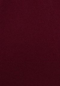 Bordeauxfarbener Strickstoff mit glatter Textur und feinem Gewebe, das am unteren Rand ein dezentes Rippmuster aufweist.