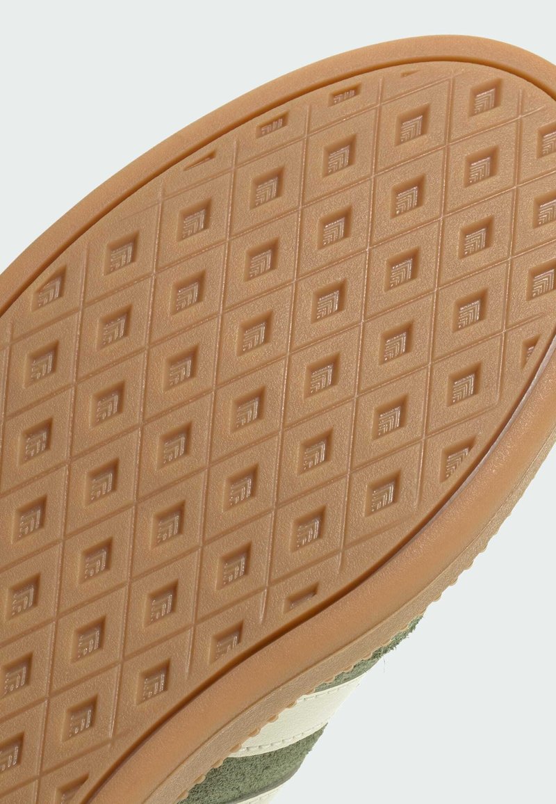 Gummisohlen mit einem honigwabenfömigen Muster in Hellbraun. Verfügt über eine strukturierte Oberfläche mit kleinen quadratischen Vertiefungen und glatten Kanten.