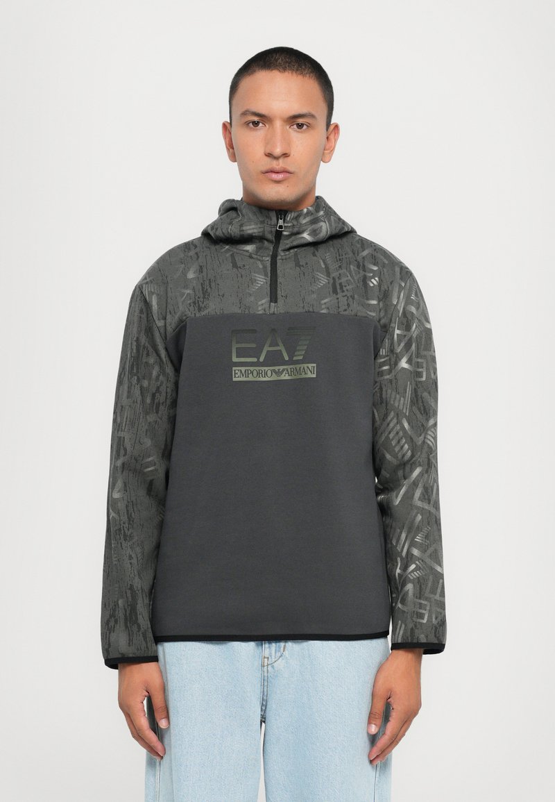 Sort hoodie med et mønstret øverste parti, featuring en halv lynlås, EA7-logo i grøn og lange ærmer; lavet af et blødt, struktureret stof.