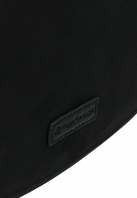 Borsa in pelle nera con superficie texture e bordo cucito, dotata di etichetta del marchio visibile in una tonalità scura abbinata.