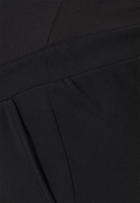 Vestido preto com uma textura suave e mate, apresentando um corpete ajustado e um leve detalhe de pregas na cintura.