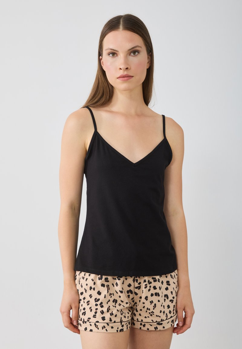 Zwarte mouwloze camisole met een V-hals, gecombineerd met beige shorts met een zwart luipaardprint patroon. Zachte stof textuur.