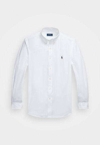 Witte katoenen blouse met lange mouwen, met een klassieke kraag, een klein blauw logo op de linkerborst en gele knopen.