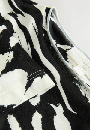 Tricou din bumbac cu dungi alb-negru, cu mâneci scurte, având o textură moale și un etichetă cu inscripția „LINE”. Model distinctiv de pensulă.