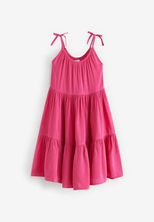 Robe rose sans manches avec tissu froncé, jupe à volants et bretelles nouées, présentée à plat sur un fond blanc.