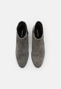 Grå mocka ankelskor med en slät yta, spetsiga tår och sidodragkedjor. Inredningen har en kontrasterande svart foder.