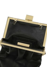 Juodas odinis rankinės modelis su auksinės spalvos rėmeliu ir užsegimu. Interjeras turi lygų juodą pamušalą su matomu prekės ženklu ir minimalistiniu dizainu.