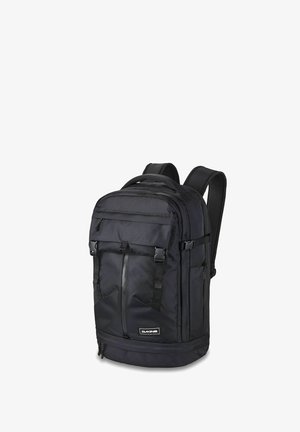 Schwarzer Dakine-Rucksack mit mehreren Reißverschlussfächern, verstellbaren Trägern und einem vorderen Logoaufnäher auf weißem Hintergrund.