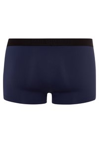 Mörkblå boxershorts tillverkade av mjukt tyg, med ett svart elastiskt midjeband med präglad logotyp, och en åtsittande design.