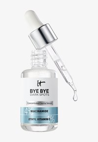 Bouteille en verre transparent étiquetée « Bye Bye Dark Spots » sérum avec compte-gouttes lâchant une goutte de liquide clair, contenant 4 % de niacinamide et 1 % de vitamine C éthylée.