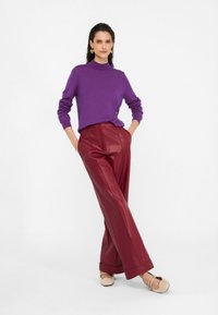 Maglione viola a maglia con dettagli a coste e bottoni laterali abbinato a pantaloni palazzo a vita alta in ecopelle bordeaux.