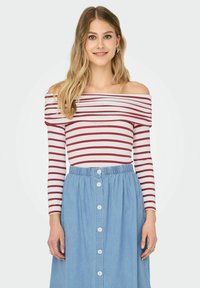 Rød- og hvidstribet off-the-shoulder langærmet topp kombineret med en blå denim knap-ned nederdel med elastisk talje.