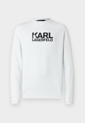 Sweatshirt blanc à manches longues, avec poignets et ourlet côtelés. Présente un grand logo noir imprimé "KARL LAGERFELD" sur le devant.