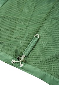 Green fabric featuring mesh panels, smooth texture, and drawstring closure with toggle. Includes a glossy accent at the attachment point.