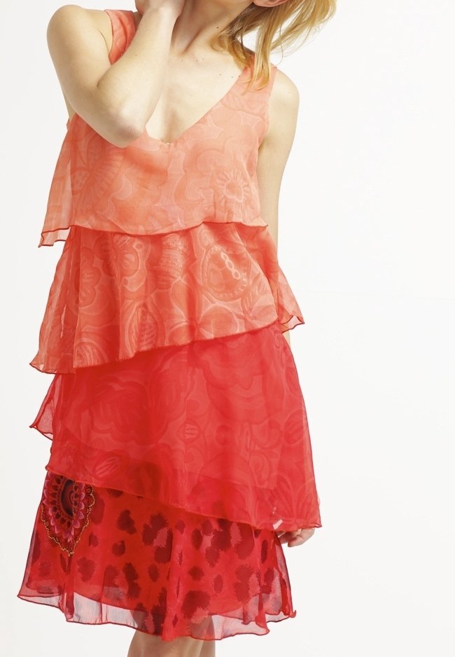 Robe à couches corail et rouge, avec un tissu transparent, un col en V et des motifs floraux ornés d'un design en forme de cœur sur la couche la plus basse.