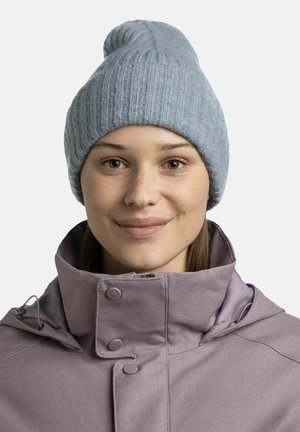 Light blue knitted beanie with a ribbed texture and a tapered top, paired with a purple collared jacket featuring snap buttons.
