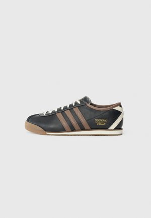 Basket en cuir noir avec des rayures brunes, des lacets blancs et des accents crème. Dotée d'une semelle en caoutchouc et d'un logo doré "adidas Italia".