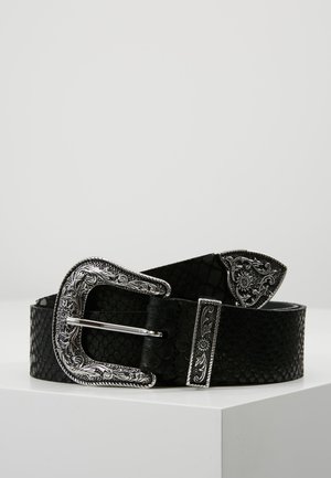 Zwarte getextureerde riem met grote sierlijke zilveren gesp, zilveren lus en zilveren uiteinde, opgerold weergegeven op een witte ondergrond tegen een effen achtergrond.